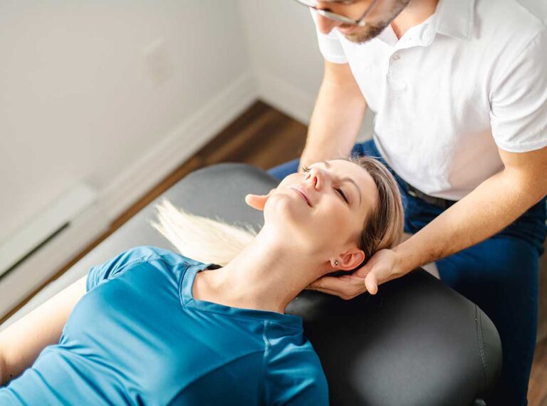 A chiropractor performing a gentle spinal adjustment on an adult patient in a clinical setting.