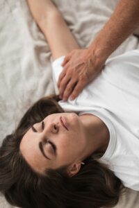 Person sleeping comfortably on their side with a supportive pillow in a quiet bedroom.